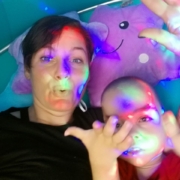 Maminka s chlapcem si hrají pod barevnými světly v relaxační místnosti se senzorickými podněty.
