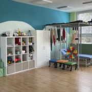 Barevná místnost pro dětskou rehabilitaci s klecovou konstrukcí, pomůckami a masážním lehátkem
