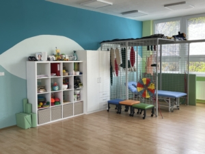Interiér centra Sarema s rehabilitačními pomůckami, barevnými sedátky a úložnými prostory.