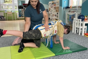 katerina uvodni Fyzioterapeutka pomáhá dívce v rehabilitačním obleku při cvičení na podložce v terapii TheraSuit